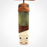 This is a large carved Koruru pendant. It is made from New Zealand Jade, Bone, Kauri wood and Brass. The face of the Koruru is carved with a traditional design in the front. It has a protruding tongue which is also carved and the back face has traditional carved designs. This is a large and very traditional pendant that is a collectors piece.