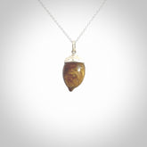 This picture shows a little wooden acorn pendant with sterling silver chain. The cap is sterling silver and is embossed with some decorative markings which give the silver cap some detail and character. Hand made by Ana Krakosky.