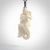 Hand carved large natural bone mermaid pendant. Hand made from real bone. Art to wear. Provided with an adjustable length black cord and packaged in a woven kete pouch. Bone mermaid necklace.
