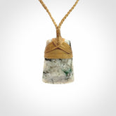 This is a handcrafted aotea stone Toki pendant.