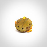 This piece is a smaller sized, oval round, disc pendant. It was carved for us by Alex Sands from a lovely bright and orange piece of New Zealand Flower jade with incredible orange and greens colours at throughout the stone. It is suspended on a yellow coloured braided cord that is length adjustable.