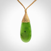 This picture shows a beautiful medium sized drop pendant carved in New Zealand Jade, pounamu. It is a lovely semi-translucent green colour, which is glows when held to the light. A gorgeous and very meaningful pendant with an adjustable cord.