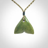 Hand carved small New Zealand Jade whale tail pendant.