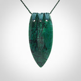 This is a handcrafted aotea stone rei puta pendant.