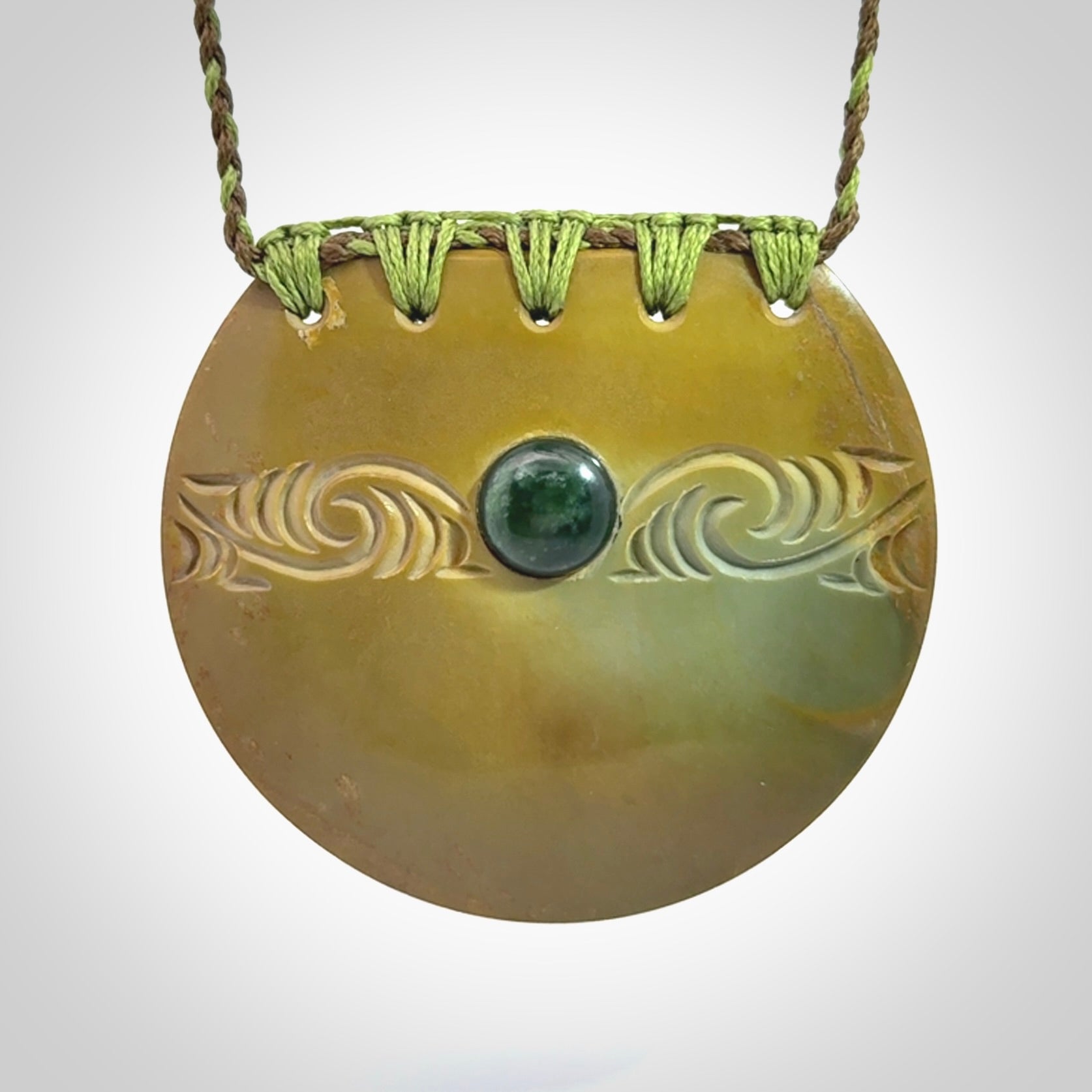 Hand carved New Zealand Flower Jade half-shield with whakarei design pendant.
