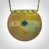 Hand carved New Zealand Flower Jade half-shield with whakarei design pendant.