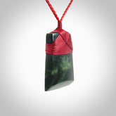 A medium sized and beautiful hand carved toki pendant. This piece is carved from New Zealand jade by NZ Pacific. This is a wonderful toki bound with a hand-plaited cord and a traditional lashing. A beautiful, traditional toki for sale online