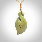 Single twist pendant. Hand carved from rare New Zealand flower jade this is a beautiful pounamu pendant. The cord is hand plaited in a tan colour and is length adjustable. It has a floret in gold. It is a delicate and very beautiful greenstone pendant. For sale online by NZ Pacific.