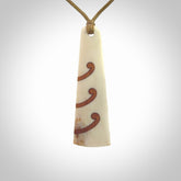 A hand carved, double sided, bone toki with triple koru, intricate pendant. The cord is a black colour and is adjustable.