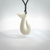 Hand carved bone hook pendant. This piece is carved with a winged decoration on the upper part. We've named it 'Avenger' after the Goddess Nike. Shipping is free worldwide.