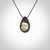 A hand carved baby in the womb pendant made from a jade and bone. This is a work of art carved in jade and bone. We deliver this pendant to you on a plaited cord. Delivery with Express Courier is included in the price.