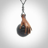 This is a very cool pendant that we've had carved for all you Basketball fans. This is a pendant with a wooden hand holding a black jade basketball. We provide this on an adjustable cord, and we ship worldwide