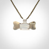 This is a hand carved deer antler dog bone dog tag. It is made from deer antler, bone and sterling silver. Hand made dog tags for your dog.