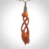 This pendant is carved from cow bone and stained with a homemade tea dye. It is a unique piece of wearable art that is sure to catch the eye. The shape is a complex twist form and has been beautifully hand carved by bone carver Yuri Terenyi.
