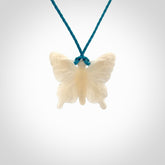 Medium sized Butterfly design pendant carved in natural bone. Real bone jewellery for sale online with NZ Pacific. Medium butterfly pendant hand made in bone, provided with paradise blue cord and packaged in a woven kete pouch.