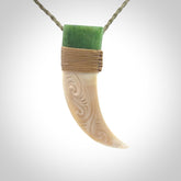 Boars Tusk Pendant with a jade cap. Hand made pendant carved from a boars tusk.