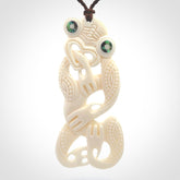 Hand carved bone Tiki pendant. Traditional art hand carved for NZ Pacific. Bone Tiki necklace with Paua Shell eyes. Delivered with Express Courier. Provided with adjustable cords and packaged in a woven kete pouch.