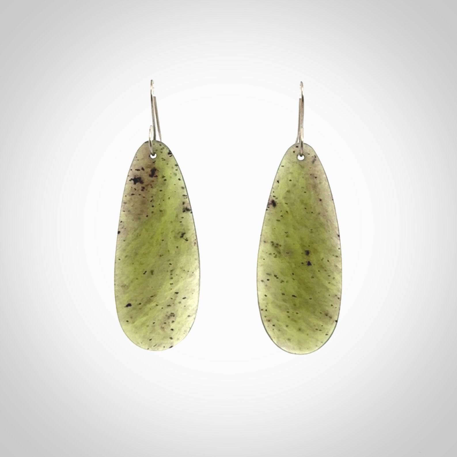 These are stunning large drop shaped jade earrings carved in New Zealand by Darren Hill. It is carved from a semi-translucent light green piece of New Zealand Jade and with Sterling Silver hooks.