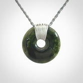These are medium sized pendants - very finely carved. They are New Zealand Jade discs with a centre hole. It is suspended from a cord which is adjustable. These are beautiful pieces of expressive jade jewellery. Unique New Zealand made pendants for men and women. Perfect gifts for all.