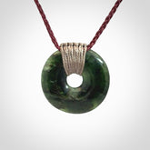 These are medium sized pendants - very finely carved. They are New Zealand Jade discs with a centre hole. It is suspended from a cord which is adjustable. These are beautiful pieces of expressive jade jewellery. Unique New Zealand made pendants for men and women. Perfect gifts for all.