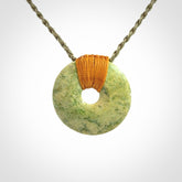 These are medium sized pendants - very finely carved. They are New Zealand Jade discs with a centre hole. It is suspended from a cord which is adjustable. These are beautiful pieces of expressive jade jewellery. Unique New Zealand made pendants for men and women. Perfect gifts for all.