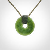 These are medium sized pendants - very finely carved. They are New Zealand Jade discs with a centre hole. It is suspended from a cord which is adjustable. These are beautiful pieces of expressive jade jewellery. Unique New Zealand made pendants for men and women. Perfect gifts for all.