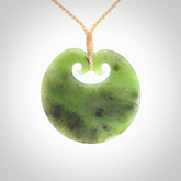 This picture shows a large contemporary pendant carved for us in New Zealand jade. The cord is a four-plait, adjustable beige coloured necklace.