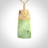 Hand carved from a lovely piece of local New Zealand flower Jade. We have suspended this from a 4-plait beige cord which can be adjusted with a couple of slip knots and beige binding.