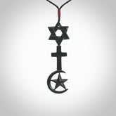 This pendant is a series of religious symbols carved in one piece of black jade. The top is a star of david, next is a christian cross and at the bottom is the crescent of islam. It is suspended on a fine, plaited black cord which is length adjustable.