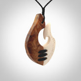 Hand carved natural bone engraved hook pendant with kauri wood. Handmade matau necklace carved from bone and wood. Made in New Zealand and for sale online at NZ Pacific. Engraved bone and wood hook necklace for lovers of wearable art.