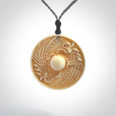 This piece is a hand carved contemporary bone shield pendant. Yuri Terenyi has carved this from Bone. It is a delightful, artistic piece of jewellery. One only necklace.