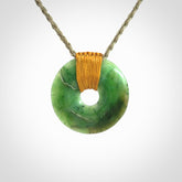 This is a hand carved disc pendant. Graeme carved this from Nephrite Jade. It is a gorgeous green colour and is an artistic piece of jewellery. Hand made by Graeme Wylie and delivered to you in a kete pouch.