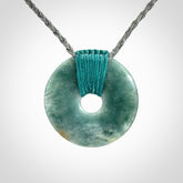 This is a hand carved disc pendant. Graeme carved this from Guatemalan Jadeite. It is a gorgeous blue colour and is an artistic piece of jewellery. Hand made by Graeme Wylie and delivered to you in a kete pouch.