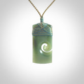 New Zealand jade toki koru pendant. Hand carved in New Zealand. Hand made New Zealand Jade jewellery. Provided with an adjustable cord and packaged in a woven kete pouch.
