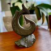 Hand carved large New Zealand Argillite Stone Matau, hook carving displayed in a New Zealand Pākohe stand sculpture. Hand carved here in New Zealand by Kerry Thompson. This is a 'one only' sculpture, a beautiful display piece.