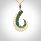 This photo shows a beautiful jade hook with bone pendant. It is handcarved from a piece of mottled green Jade, with fascinating mauve tinges through the stone. We have this on a adjustable cord. We ship this worldwide with an express courier service. Postage is free.