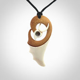 A hand carved bone contemporary bird pendant. The cord is a black colour and is a fixed length. A medium sized hand made contemporary necklace by New Zealand artist Kerry Thompson. Kerry has stained parts of the bone which really add to the dimension of this pendant. One off work of art to wear.