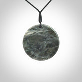 This cupped disc pendant, is carved from a very striking New Zealand Nelson jade.