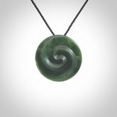 This pendant is a medium sized double koru necklace carved from a New Zealand Jade with Mother of Pearl inlay. Kyohei Noguchi carved this piece for us so the workmanship is outstanding. Handmade in New Zealand, a beautiful piece of jade jewellery.