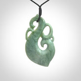 This picture shows a contemporary manaia with hook pendant carved for us by Kyohei Noguchi. It is a light green colour in traditional manaia design. We have plaited a cord in black and made it length adjustable. This is a very beautiful piece of art to wear.