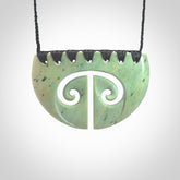 A hand carved double koru breastplate pendant from New Zealand Kokopu Jade. The cord is a black colour and is an adjustable length. A large hand made double Koru shield necklace by New Zealand artist Kerry Thompson.