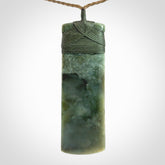 A large and beautiful hand carved toki pendant. This piece is carved from New Zealand jade by NZ Pacific. This is a wonderful large toki bound with a tan cord and a traditional sage green lashing. A beautiful, traditional toki for sale online.