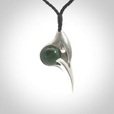 This is a hand carved Sterling Silver Huia bird pendant with New Zealand Jade insert. This is a medium sized necklace and is provided with an adjustable black cord.