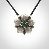 This is a hand carved Sterling Silver Manuka Flower pendant with New Zealand Jade insert. This is a medium sized necklace and is provided with an adjustable black cord.