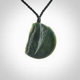 This piece is a contemporary disc pendant hand carved in New Zealand jade.