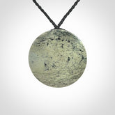 This piece is a contemporary disc pendant hand carved in New Zealand jade.