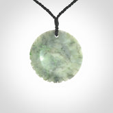 This piece is a contemporary disc pendant hand carved in New Zealand jade.
