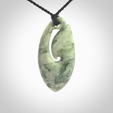 A hand carved medium New Zealand Jade Hook, Matau, necklace. The cord is adjustable