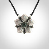 This is a hand carved Sterling Silver Manuka Flower pendant with New Zealand Jade insert. This is a medium sized necklace and is provided with an adjustable black cord.
