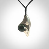 This is a hand carved Sterling Silver Saddleback, Kokako, bird pendant with British Columbian Jade insert. This is a medium sized necklace and is provided with an adjustable black cord.
